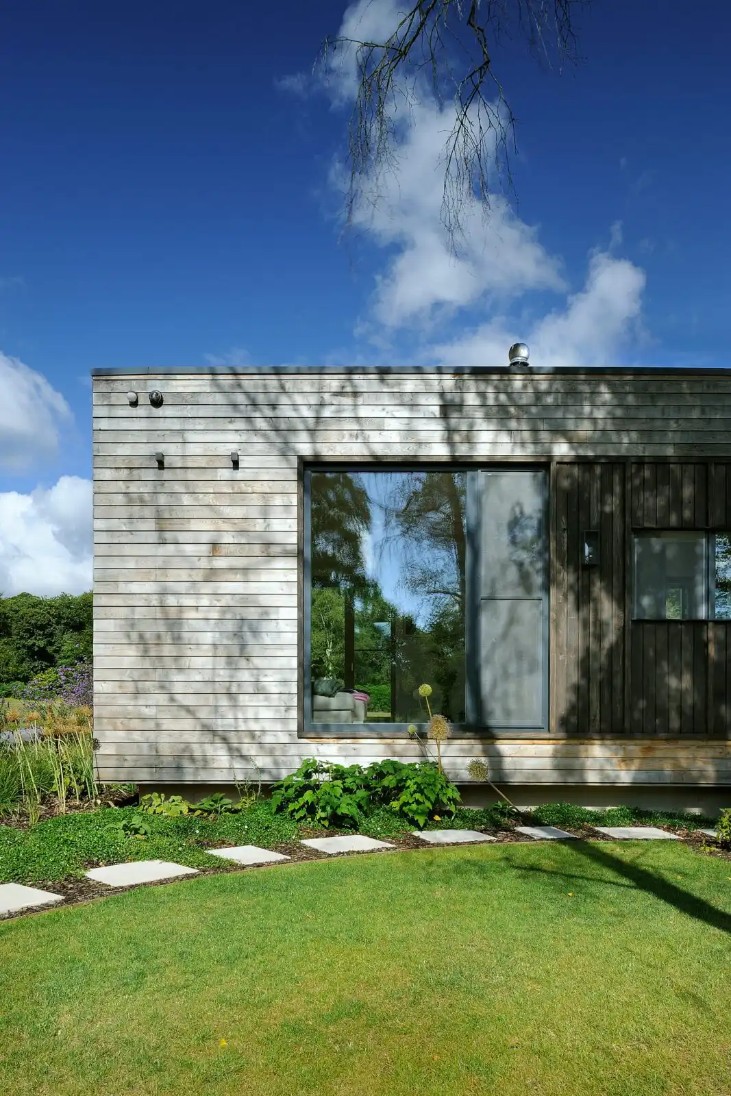 Timber cladding of forest lodge and nature in the reflections